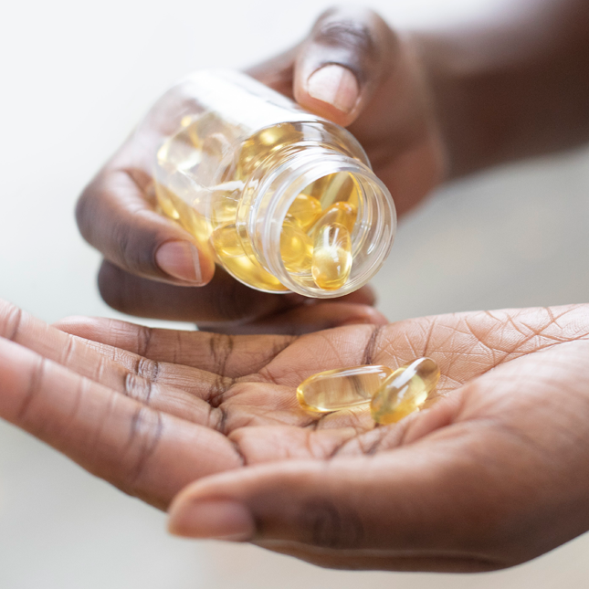 person pouring supplements from bottle into hand